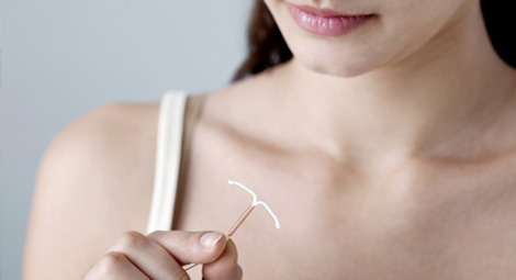 A woman holding an IUD
